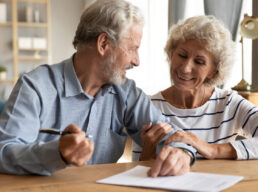 70s couple discuss agreement ready to sign contract